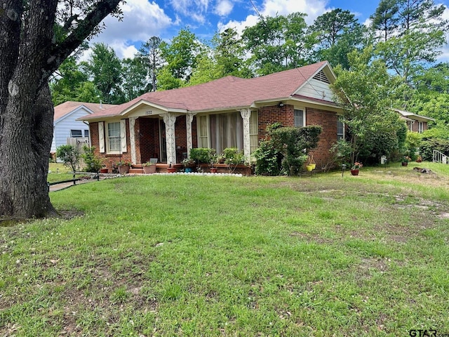 ranch-style house featuring brick siding and a front yard
