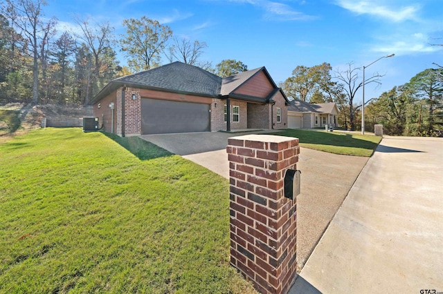 view of front facade featuring a front yard, a garage, and central AC unit