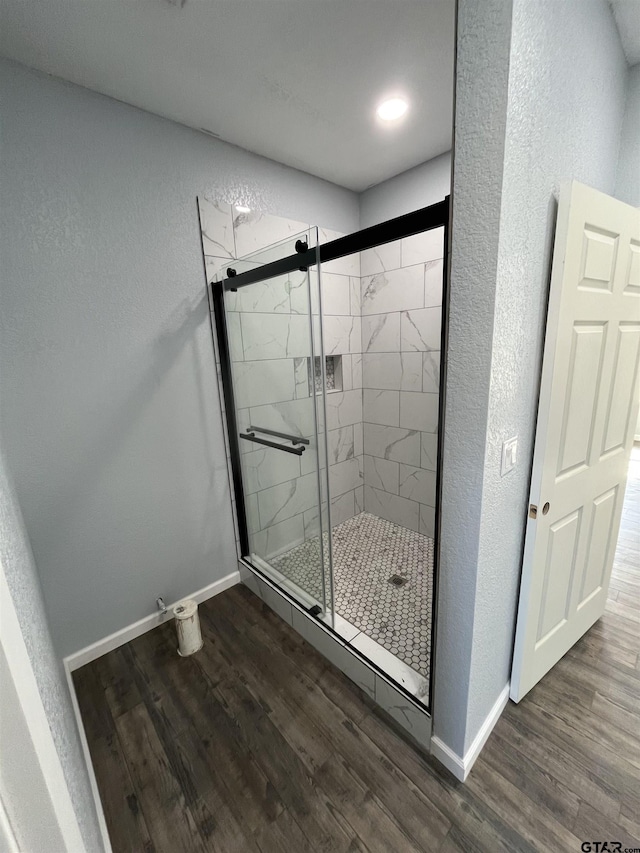 bathroom featuring a shower with door and hardwood / wood-style floors