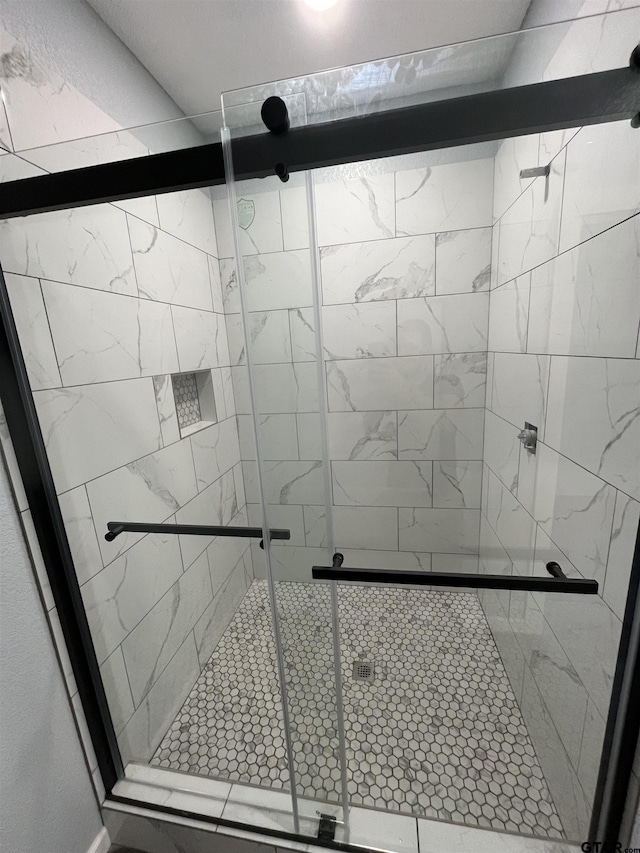 bathroom featuring a shower with shower door