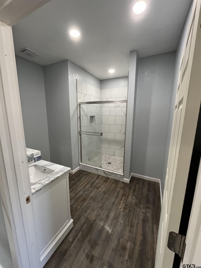 bathroom with an enclosed shower, vanity, and hardwood / wood-style flooring