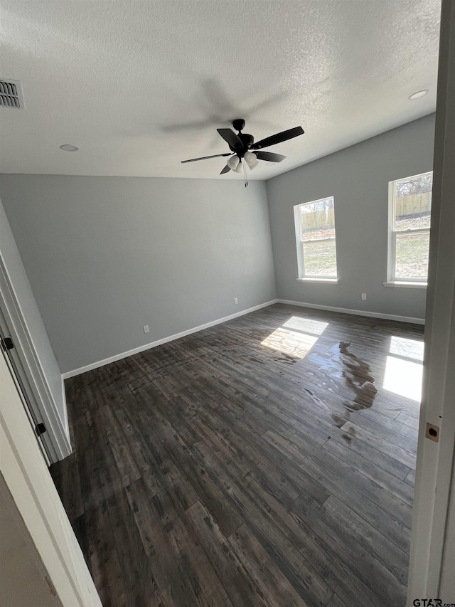 empty room with a textured ceiling, dark hardwood / wood-style floors, and ceiling fan