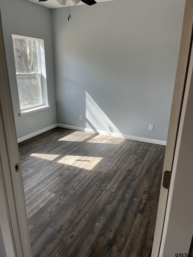 spare room featuring dark wood-type flooring and ceiling fan