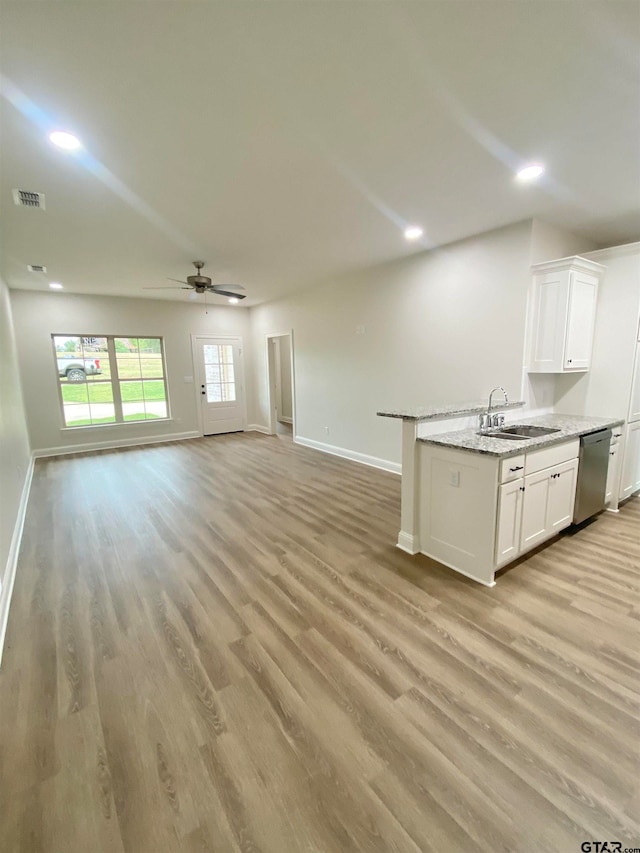 kitchen with light hardwood / wood-style flooring, white cabinetry, stainless steel dishwasher, and sink