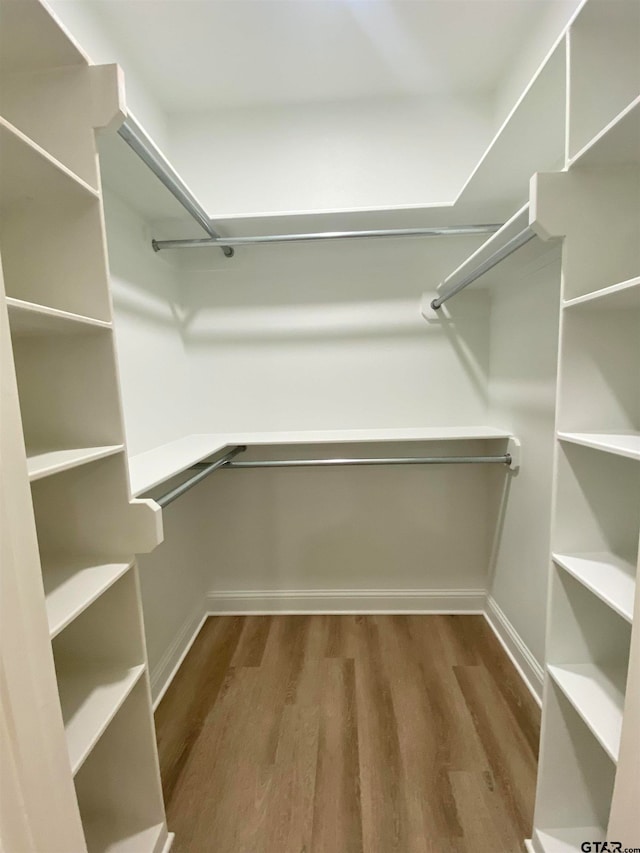 walk in closet with hardwood / wood-style floors