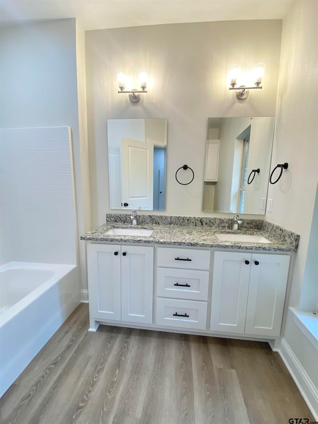 bathroom featuring a tub, hardwood / wood-style floors, and vanity