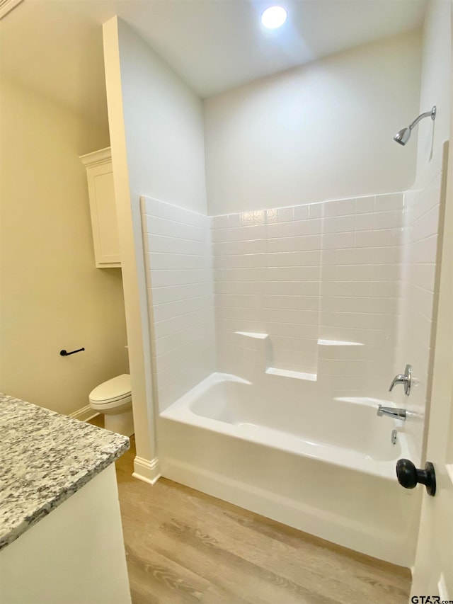 bathroom featuring washtub / shower combination, wood-type flooring, and toilet