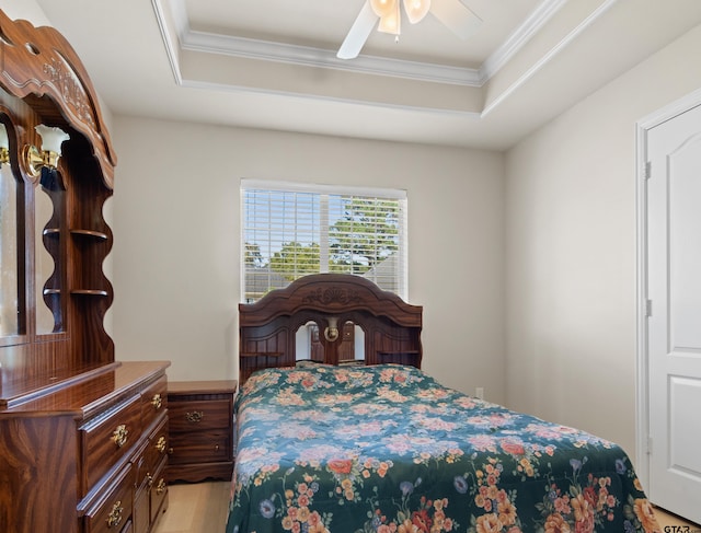 bedroom with a tray ceiling, ceiling fan, light hardwood / wood-style floors, and ornamental molding