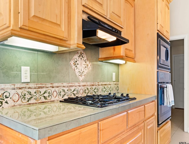 kitchen with tile patterned floors, light brown cabinets, backsplash, and appliances with stainless steel finishes