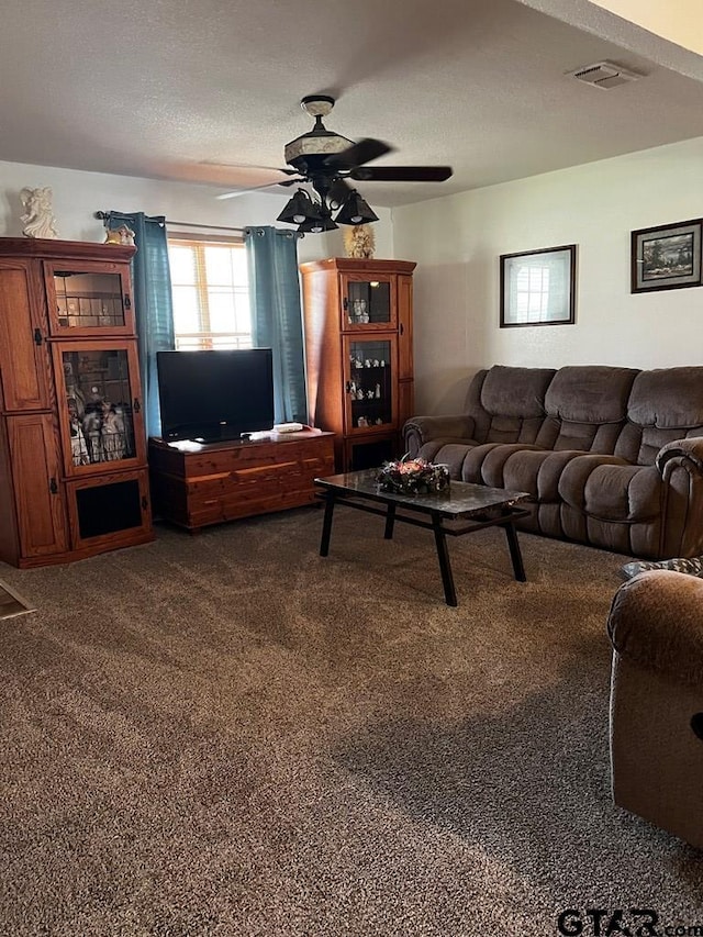 carpeted living room featuring a textured ceiling and ceiling fan