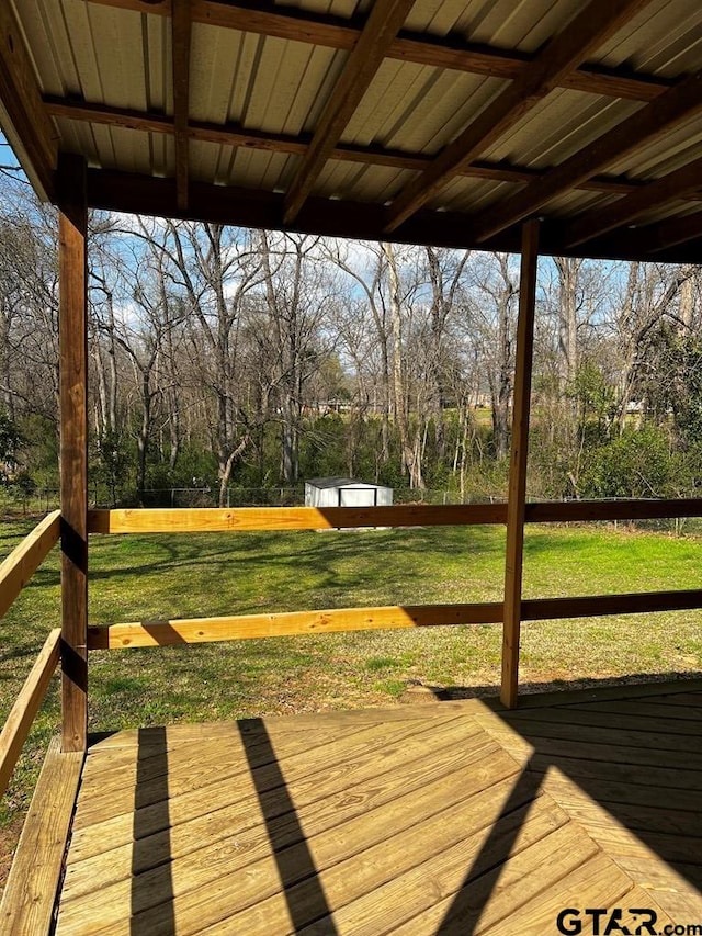 wooden terrace with a yard and a storage shed