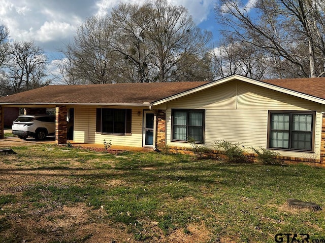 single story home featuring a carport and a front yard