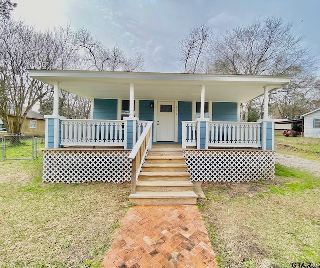 view of front of property featuring covered porch and a front lawn