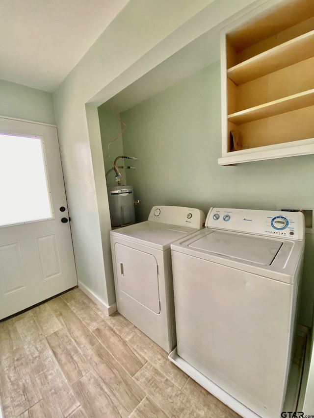 laundry room featuring washer and clothes dryer, light hardwood / wood-style floors, and electric water heater