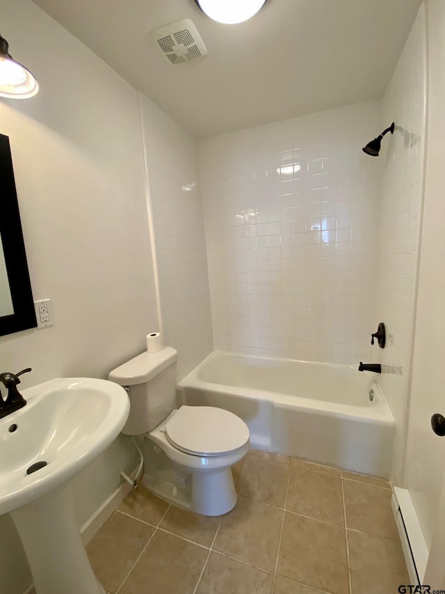 bathroom featuring tiled shower / bath, tile patterned floors, baseboard heating, and toilet