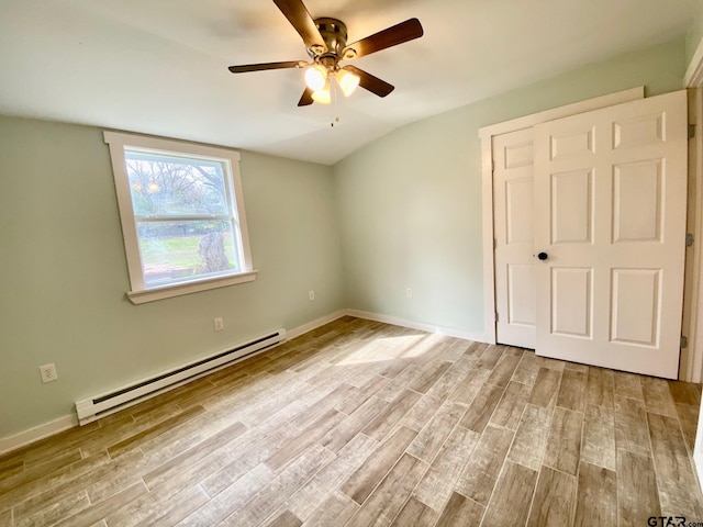 unfurnished bedroom featuring a baseboard heating unit, vaulted ceiling, ceiling fan, and light wood-type flooring