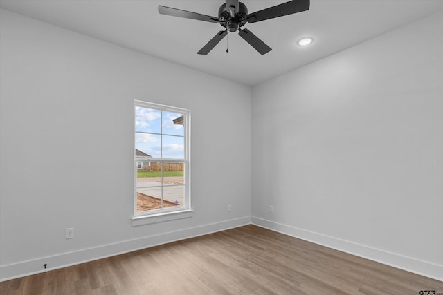 spare room with hardwood / wood-style floors and ceiling fan