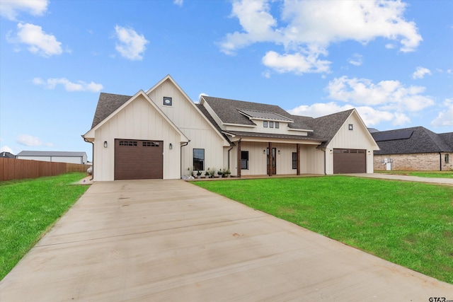 modern farmhouse with a garage, a front lawn, and covered porch