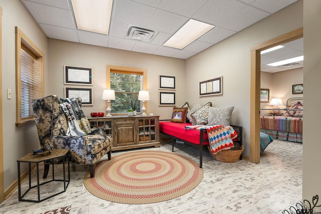 living area with a paneled ceiling