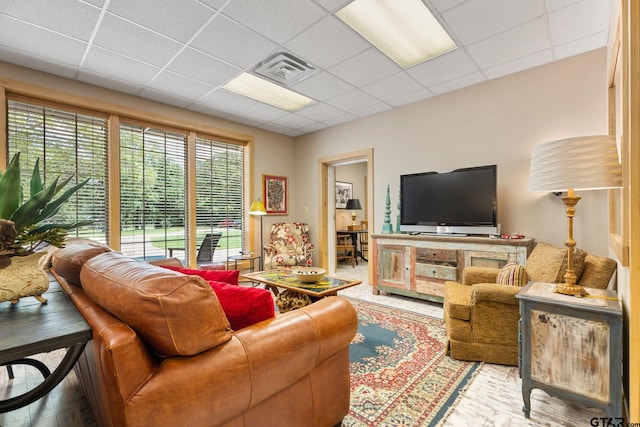 living room with a paneled ceiling and wood-type flooring