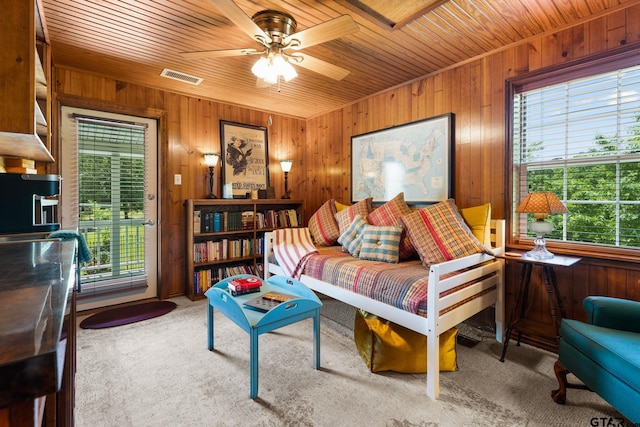 living room with wood walls, ceiling fan, and wooden ceiling