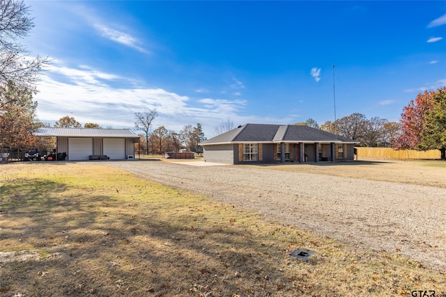 ranch-style home featuring an outbuilding, a garage, and a front yard