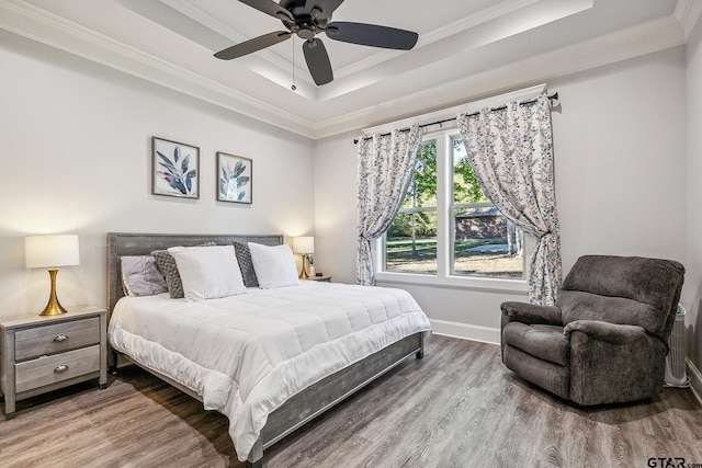 bedroom featuring hardwood / wood-style floors, ceiling fan, and crown molding