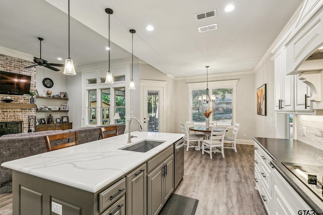 kitchen with gray cabinetry, sink, a center island with sink, and white cabinets