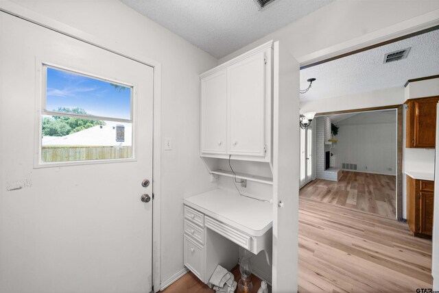 608 Meadow Crk, Tyler, TX 75703 - laundry room featuring light wood-style floors and a textured ceiling