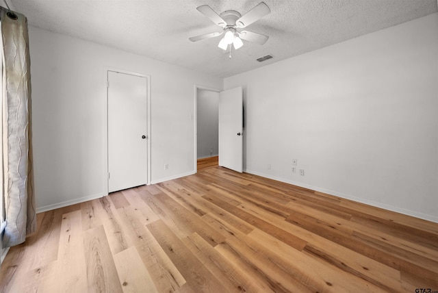 608 Meadow Crk, Tyler, TX 75703 - unfurnished bedroom featuring light wood-style floors, ceiling fan, and a textured ceiling