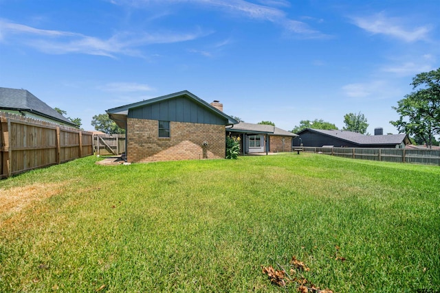 608 Meadow Crk, Tyler, TX 75703 - back of property with brick siding, a chimney, a fenced backyard, and board and batten siding