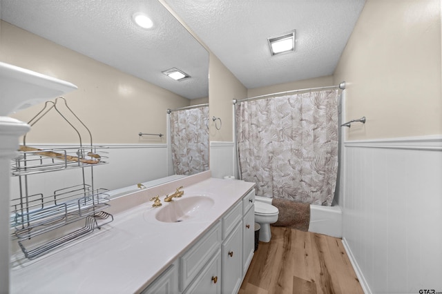 608 Meadow Crk, Tyler, TX 75703 - full bath with wood finished floors, wainscoting, a textured ceiling, vanity, and shower / tub combo