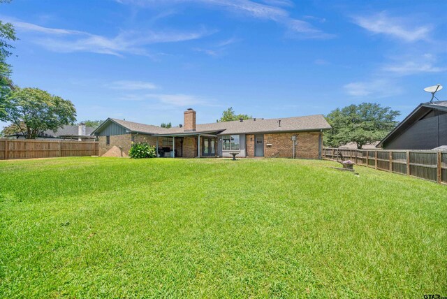 608 Meadow Crk, Tyler, TX 75703 - back of house with brick siding, a fenced backyard, and a chimney