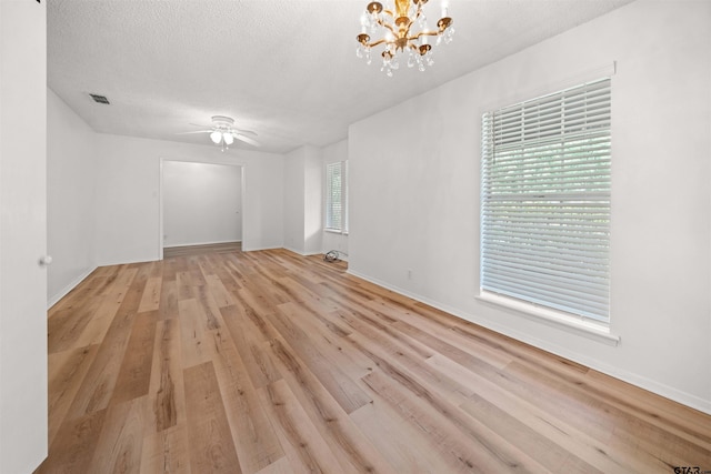 608 Meadow Crk, Tyler, TX 75703 - empty room with ceiling fan, wood finished floors, a chandelier, and a textured ceiling