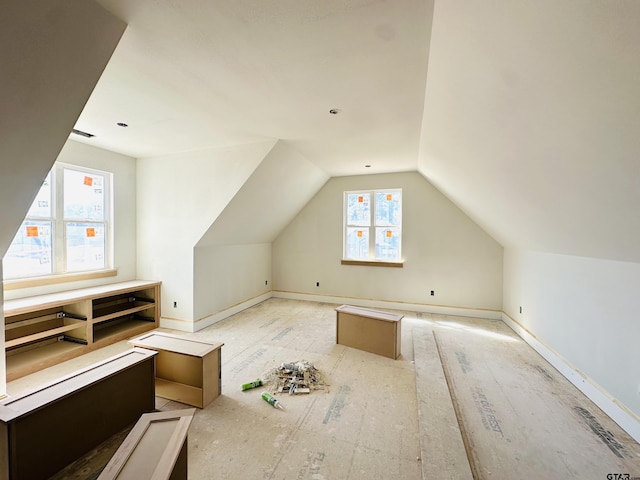 bonus room featuring lofted ceiling and baseboards