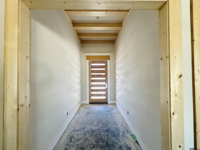 interior space featuring baseboards and beam ceiling