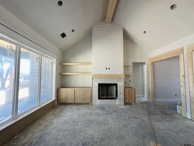 unfurnished living room with high vaulted ceiling, a large fireplace, plenty of natural light, and beam ceiling