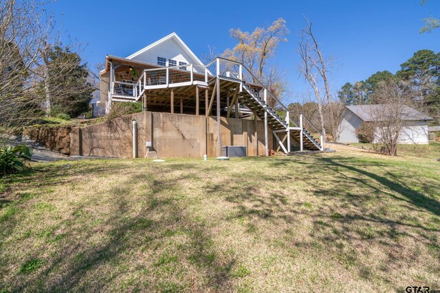 back of property featuring a lawn and stairway