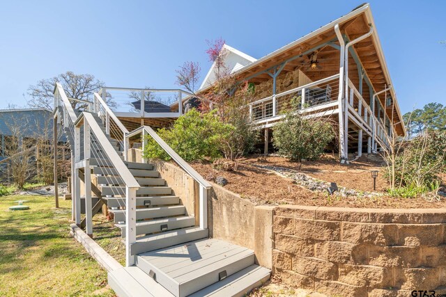 view of home's exterior with stairway and a ceiling fan