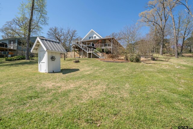 view of yard featuring an outdoor structure, a storage shed, and stairway