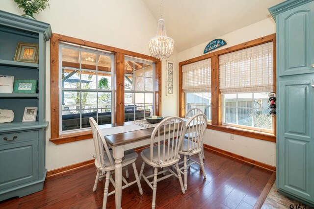 dining area featuring dark wood-type flooring, vaulted ceiling, an inviting chandelier, and plenty of natural light