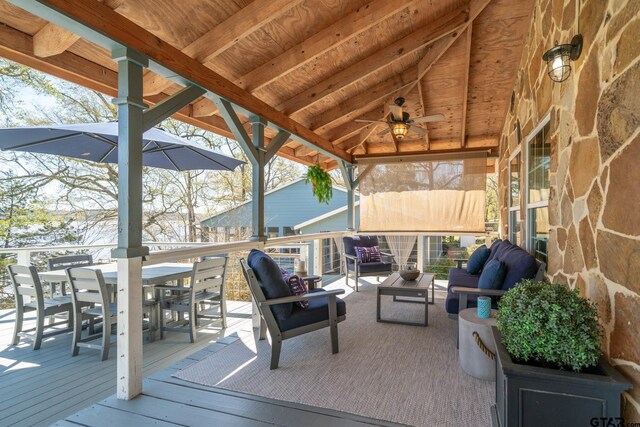wooden deck with outdoor lounge area, outdoor dining space, and a ceiling fan