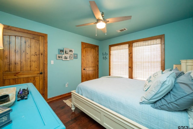 bedroom featuring baseboards, visible vents, a ceiling fan, and dark wood finished floors