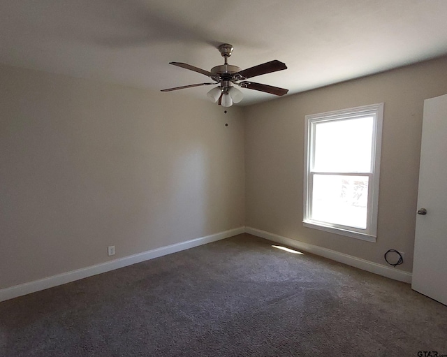 empty room featuring carpet flooring, baseboards, and a ceiling fan