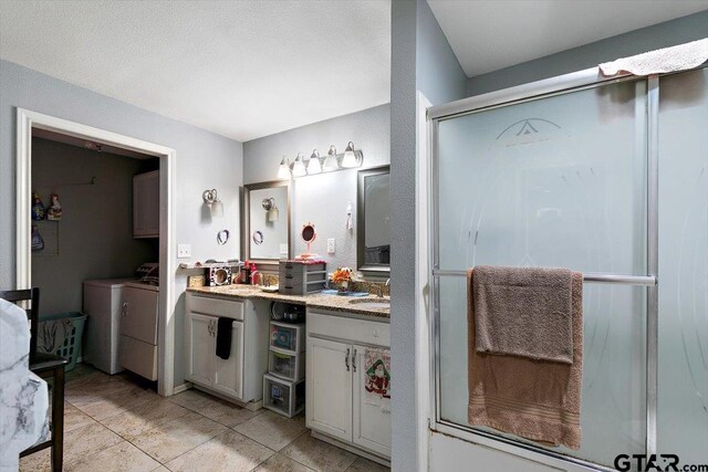 182 Moses St, Rusk, TX 75785 - bathroom featuring separate washer and dryer, vanity, a shower stall, and tile patterned floors