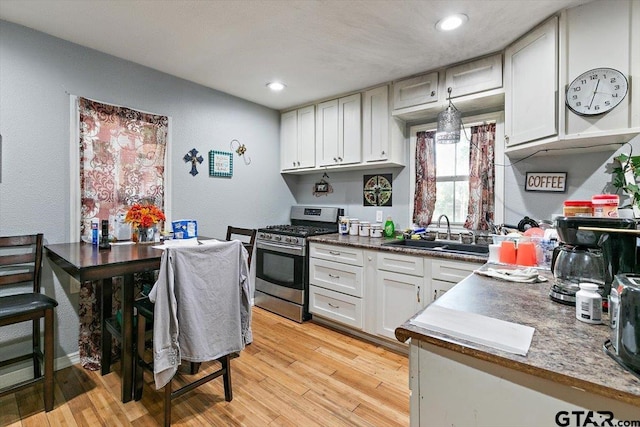 182 Moses St, Rusk, TX 75785 - kitchen with gas range, light wood-type flooring, white cabinets, and recessed lighting