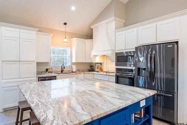 kitchen featuring appliances with stainless steel finishes, white cabinets, blue cabinets, and a sink