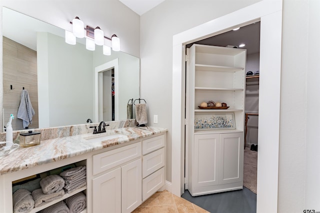 full bathroom featuring a spacious closet and vanity