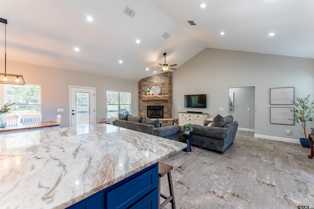 kitchen with blue cabinetry, a breakfast bar area, visible vents, and a healthy amount of sunlight