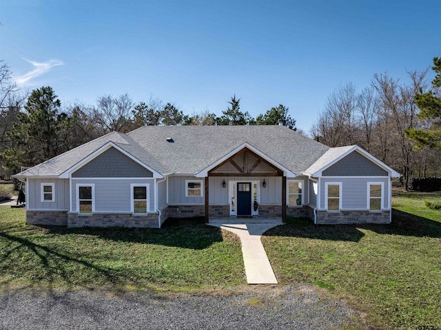 craftsman inspired home with stone siding, a shingled roof, board and batten siding, and a front yard